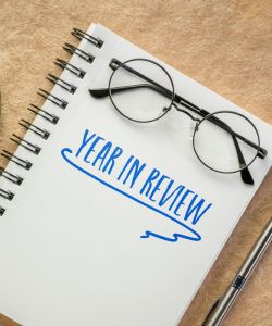 year in review written on notebook with glasses