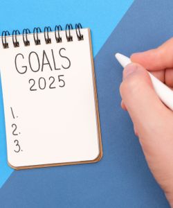 Goals 2025 written on notepad with 3 bullet points below.